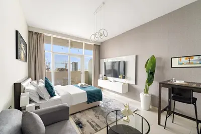 a bedroom with a bed and a desk and a tv at FIRST CLASS Studio Luxe Cozy Living in Dubai