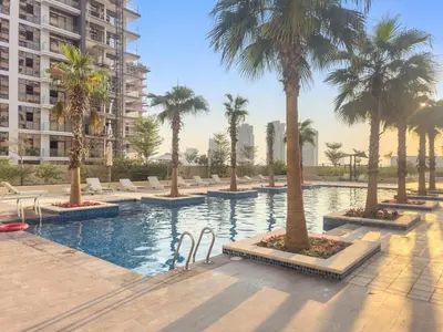 a swimming pool with palm trees in a building at FIRST CLASS Studio Luxe Cozy Living in Dubai