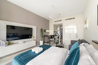 a bedroom with a large white bed and a couch at FIRST CLASS Studio Luxe Cozy Living in Dubai
