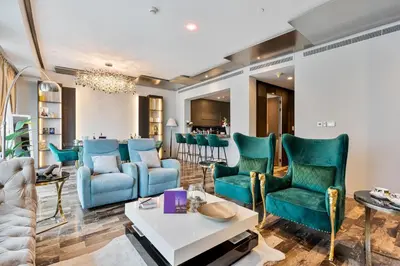 a living room with blue chairs and a table at Highend 2BR Palm Sea View with Pool and Nightlife Marina in Dubai