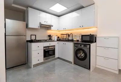 a kitchen with white cabinets and a dishwasher at Dubai Marina - 1 BHK Stunning Apartment in Dubai