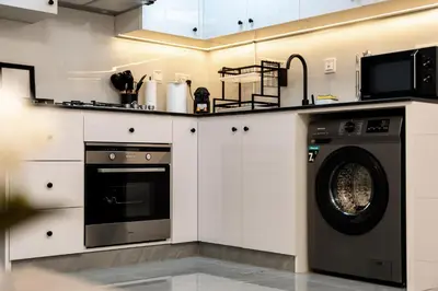 a kitchen with a washing machine and a microwave at Dubai Marina - 1 BHK Stunning Apartment in Dubai