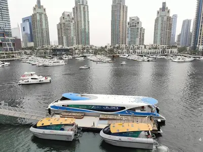 three boats are docked in a river in a city at Marina Bliss Luxe Stay with Waterfront and Palm Views in Dubai