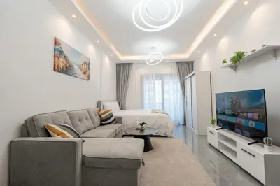 a living room with a couch and a tv at Dubai Marina - Lovely Studio Apartment in Dubai