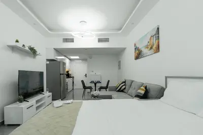 a bedroom with a large bed and a living room at Dubai Marina - Lovely Studio Apartment in Dubai
