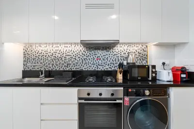 a kitchen with a stove and a washing machine at Aykon City Panoramic Skyline View in Dubai