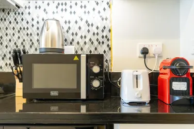 a microwave sitting on a counter with a coffee maker at Aykon City Panoramic Skyline View in Dubai