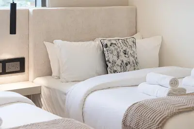 a bedroom with two beds with white pillows at Elegant 4BR Villa, Bali Pool Retreat, Ruba, A Ranches 3 in Dubai