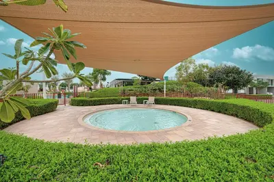 a patio with an umbrella over a swimming pool at Elegant 4BR Villa, Bali Pool Retreat, Ruba, A Ranches 3 in Dubai
