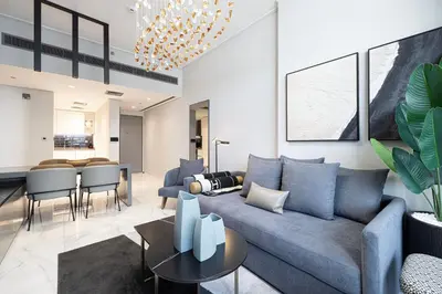 a living room with a blue couch and a table at 2BR Dubai Gem steps from Dubai Mall & Burj in Dubai