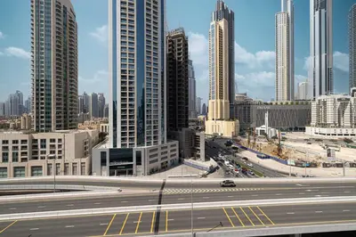 a city with a highway in front of tall buildings at 2BR Dubai Gem steps from Dubai Mall & Burj in Dubai