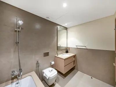 a bathroom with a sink and a toilet and a mirror at EMAAR GRANDE 1BR Downtown I Steps to Fountain & Dubai Mall in Dubai