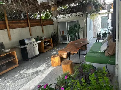 an outdoor patio with a wooden bench and a kitchen at Private Cottage with bbq area 5 min walk to beach! in Dubai