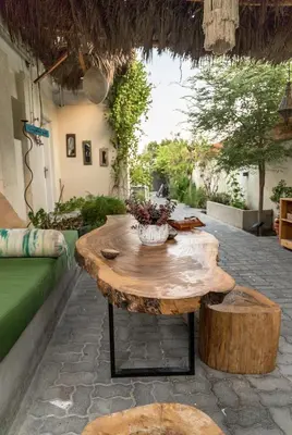 a wooden table with a vase on top of it at Private Cottage with bbq area 5 min walk to beach! in Dubai