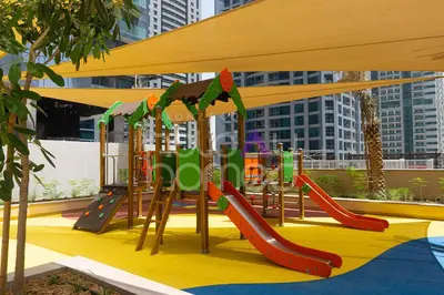 a playground with a slide and a play structure at Spacious and Elegant 2BR Marina Gate 2 in Dubai