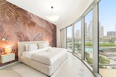 a bedroom with a large bed and large windows at Panoramic 2BR with Pool & Burj View Next to Mall in Dubai