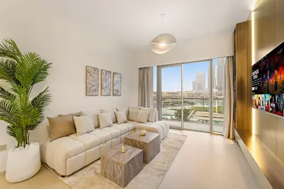 a living room with a white couch and a large window at Panoramic 2BR with Pool & Burj View Next to Mall in Dubai
