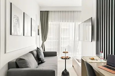 a living room with a couch and a desk with a laptop at Central Downtown Studio by Burj Khalifa & Mall in Dubai