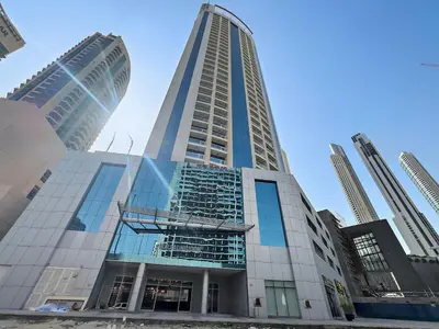 a tall building with glass windows in a city at Central Downtown Studio by Burj Khalifa & Mall in Dubai