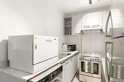 a kitchen with white appliances and white cabinets at Central Downtown Studio by Burj Khalifa & Mall in Dubai