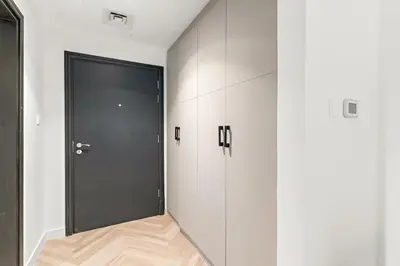 a hallway with a black door and white cabinets at Central Downtown Studio by Burj Khalifa & Mall in Dubai