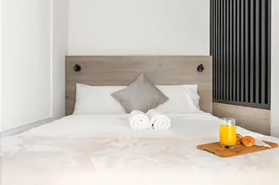 a bed with a tray of towels and a glass of orange juice at Central Downtown Studio by Burj Khalifa & Mall in Dubai