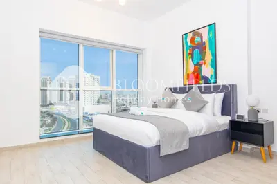 a bedroom with a bed and a large window at Bloomfields Stylish 1br Orchid Residence in Dubai