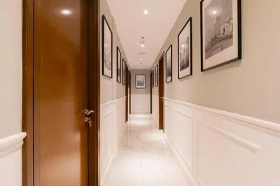 a hallway with framed pictures on the walls at 4BHK in Business Bay w Burj Khalifa View Noora 4304 in Dubai
