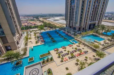 an aerial view of a resort with two pools at 4BHK in Business Bay w Burj Khalifa View Noora 4304 in Dubai