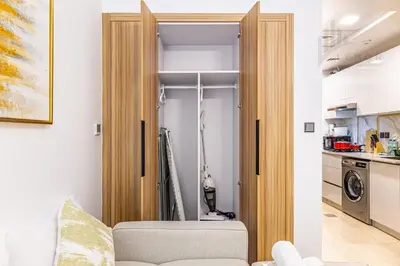 a living room with a door open to a kitchen at Chic Studio Living JVC in Dubai