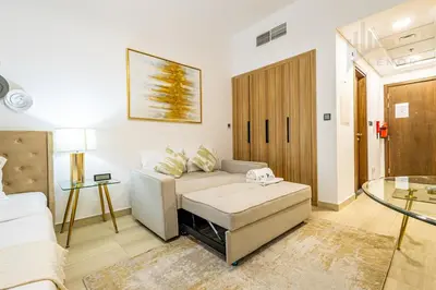 a living room with a couch and a table at Chic Studio Living JVC in Dubai