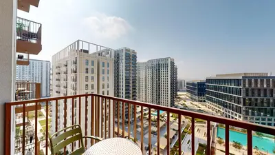 a balcony with a view of a city with tall buildings at Cozy and Modern 1BR in Dubai Hills in Dubai