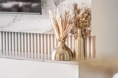 two gold vases sitting on a counter with flowers in them at Luxury 4BR with Hermes Touch & Burj Khalifa View in Dubai
