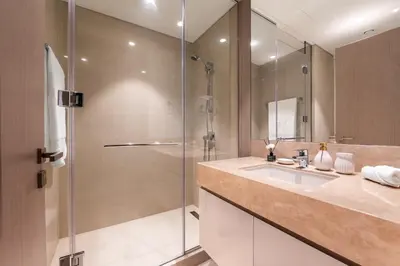 a bathroom with a sink and a glass shower at Luxury 4BR with Hermes Touch & Burj Khalifa View in Dubai