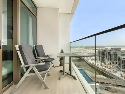 two chairs and a table on a balcony with a view at Palace residence creek harbour in Dubai