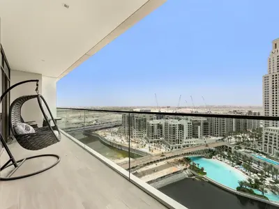 a balcony with a swing and a view of a city at Palace residence creek harbour in Dubai