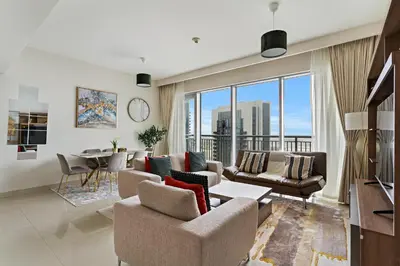 a living room with a couch and chairs and a table at Elegant Creekside 1BR with Panoramic Views in Dubai