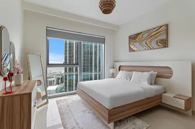 a bedroom with a bed and a large window at Elegant Creekside 1BR with Panoramic Views in Dubai