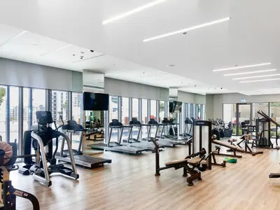 a gym with treadmills and elliptical machines at Elegant Creekside 1BR with Panoramic Views in Dubai