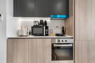 a kitchen with a stove and a microwave at Waves - Elegant & Lavish Studio Apt for 4 in JVC in Dubai