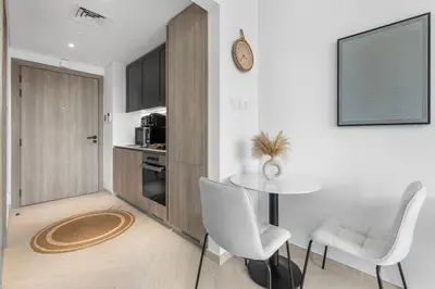 a living room with a table and two chairs at Waves - Elegant & Lavish Studio Apt for 4 in JVC in Dubai