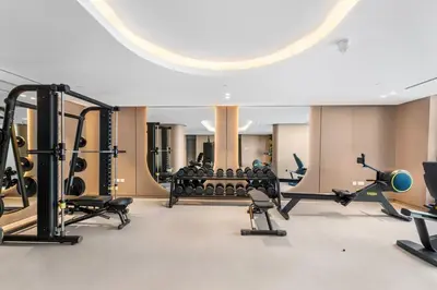 a gym with several treadmills and exercise bikes at Waves - Elegant & Lavish Studio Apt for 4 in JVC in Dubai