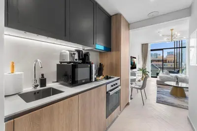 a kitchen with a sink and a microwave at Waves - Elegant & Lavish Studio Apt for 4 in JVC in Dubai