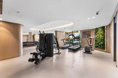 a gym with treadmills and exercise equipment in a building at Waves - Elegant & Lavish Studio Apt for 4 in JVC in Dubai