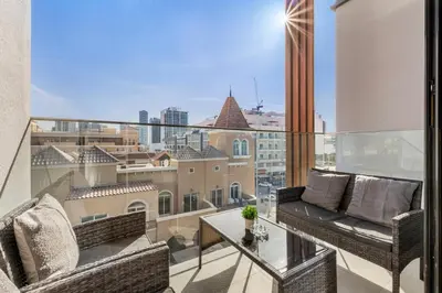 a balcony with two chairs and a table with a view at Waves - Elegant & Lavish Studio Apt for 4 in JVC in Dubai