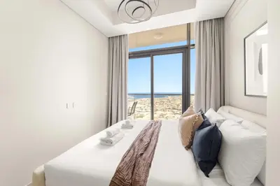 a bedroom with a bed with a view of the beach at Silkhaus Elite 2BR near Safa Park in Aykon City in Dubai