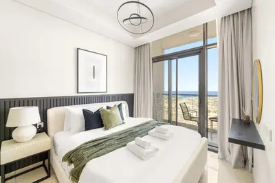 a bedroom with a bed with a view of the ocean at Silkhaus Elite 2BR near Safa Park in Aykon City in Dubai