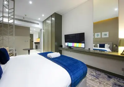 a bedroom with a large bed and a flat screen tv at Modern Canal View with Balcony Damac Prive Dubai in Dubai