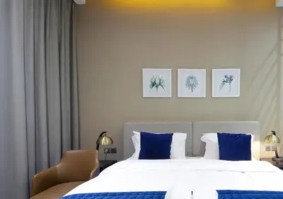 a bedroom with a large bed with blue pillows at Modern Canal View with Balcony Damac Prive Dubai in Dubai