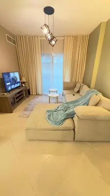 a living room with a couch and a tv at Metro Access,Insulated in Dubai